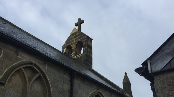 old church roof with cross pillar and arch architecture detailing