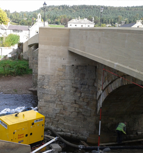 grade 2 listed bridge having restorative work completed underneath by person in high-vis 