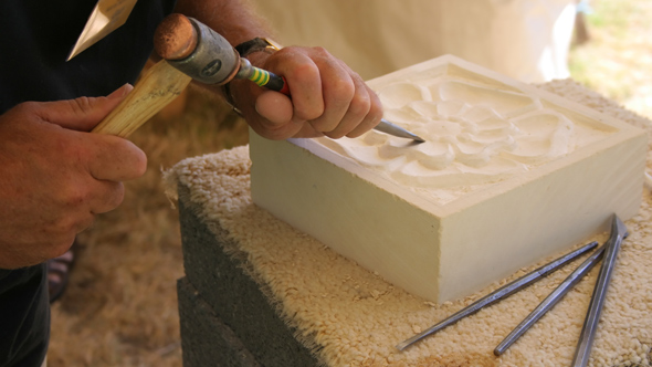 hand carving english rose into monument stone slab